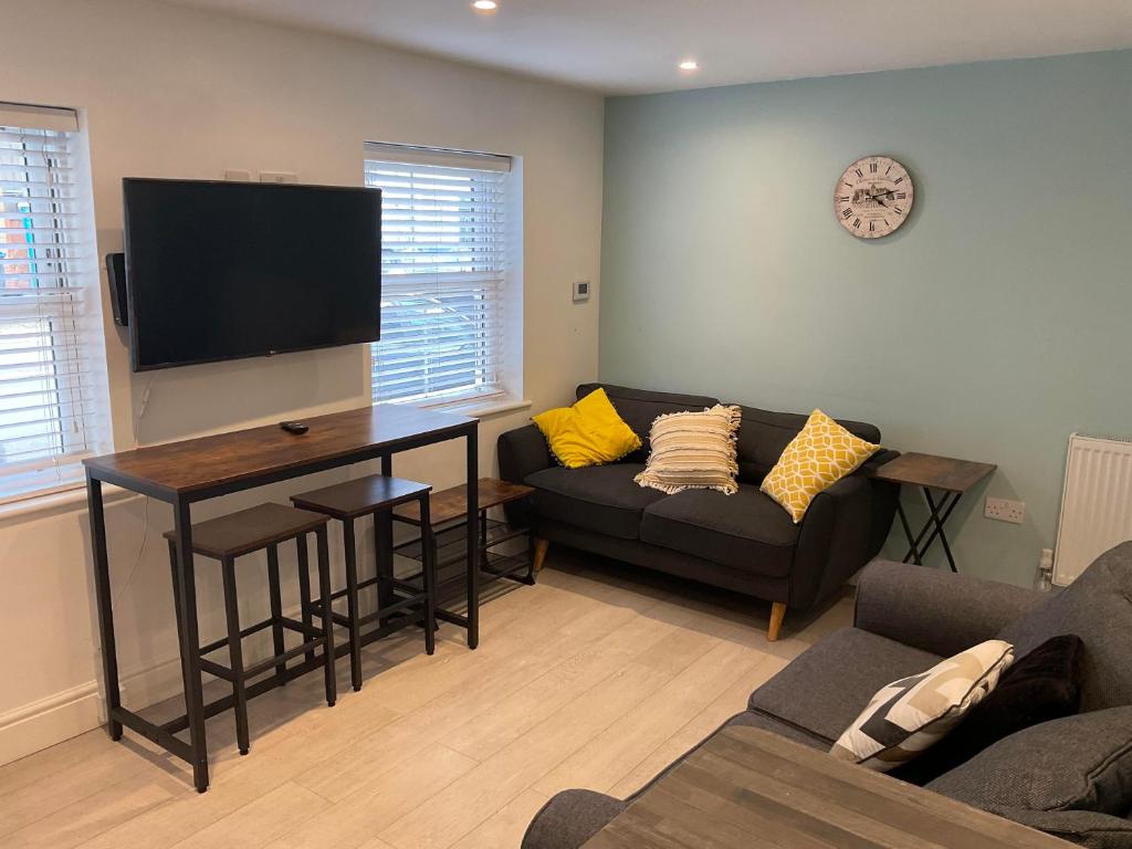 ein Wohnzimmer mit einem Sofa und einem Tisch in der Unterkunft 2 bed Home From Home Apartments in London