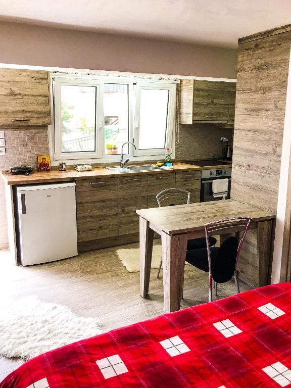 kuchnia ze stołem, zlewem i lodówką w obiekcie Soula’s cosy apartments w Kalambace