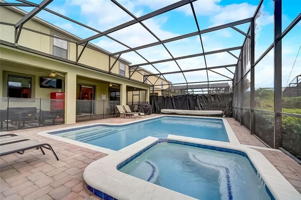 a swimming pool with a glass roof on a patio at 6BR Resort Private Pool BBQ in Davenport
