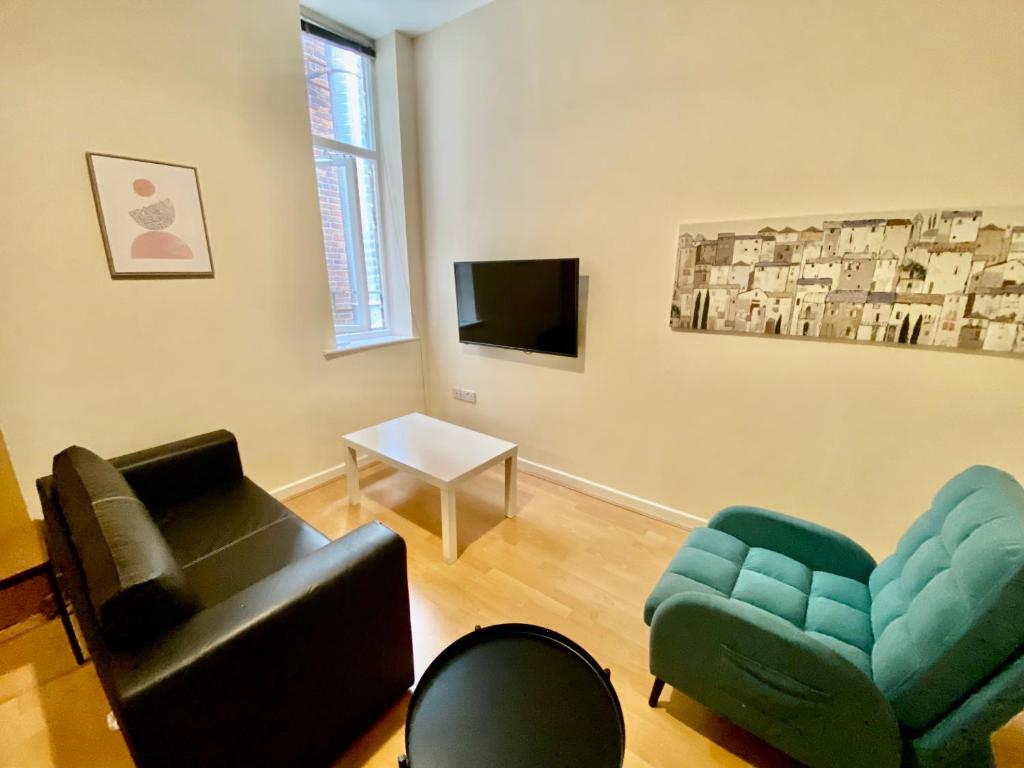a living room with a couch and chairs and a tv at Elmcroft Apartments Halifax City Centre in Halifax