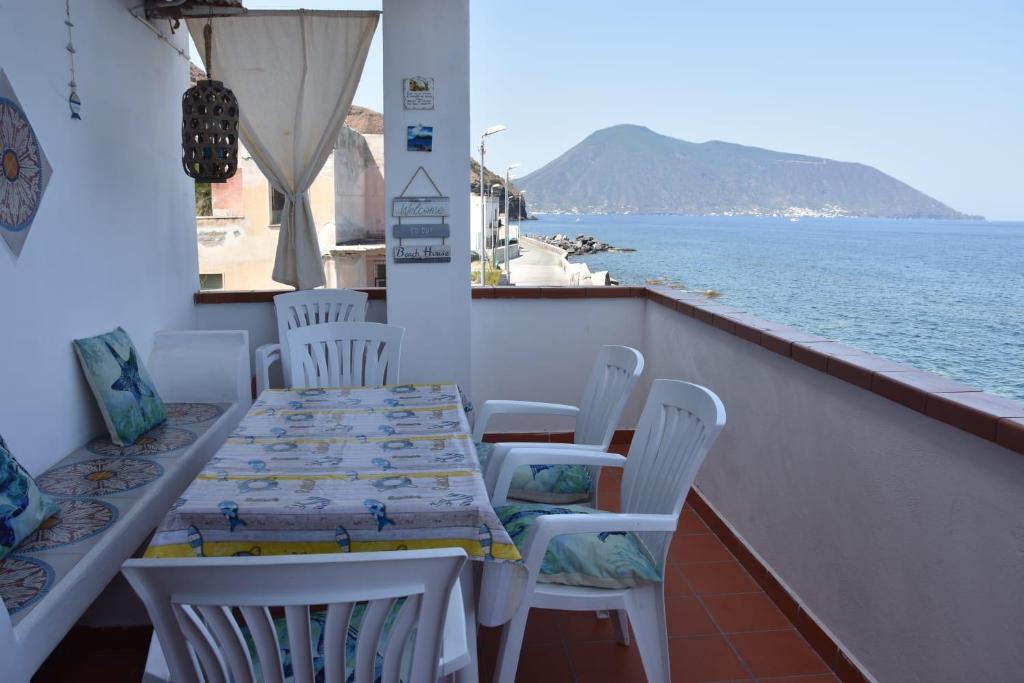 un tavolo e sedie su un balcone vicino all'acqua di Casa Caterina ad Acquacalda