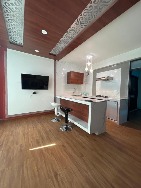 a room with a kitchen with a counter and a tv at Hotel Residencia SOGU in Ayacucho