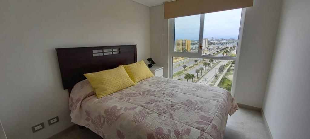 1 dormitorio con cama y ventana grande en Departamento La Herradura, en Coquimbo