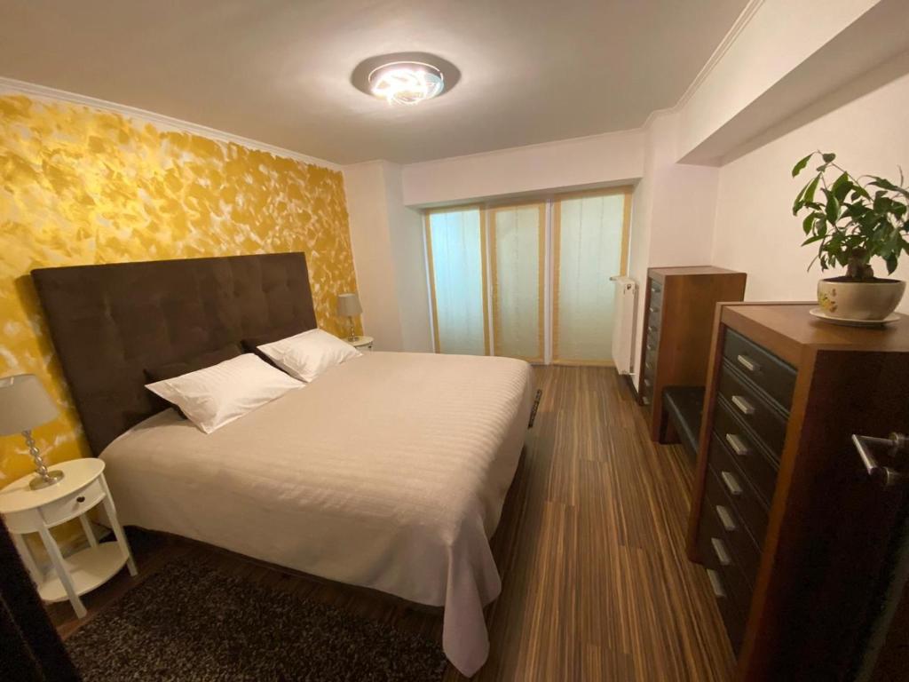 a small bedroom with a bed and a dresser and aarijuana at Premium Apartment Targoviste in Târgovişte