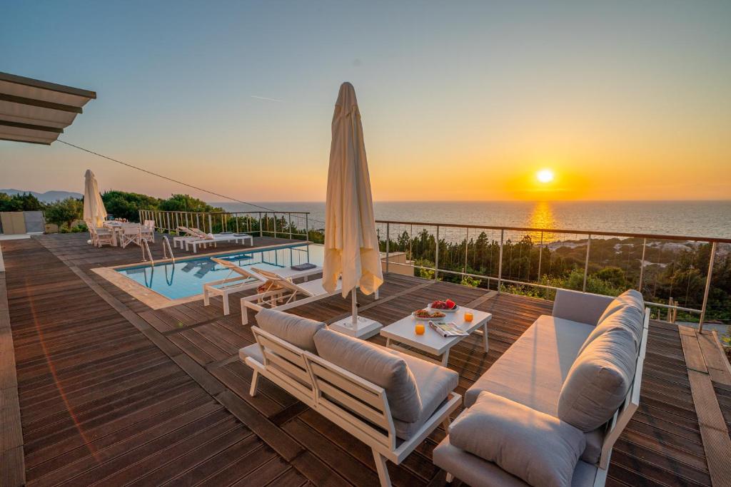 a villa with a swimming pool and a sunset at Baklava Villa in Fiskardo