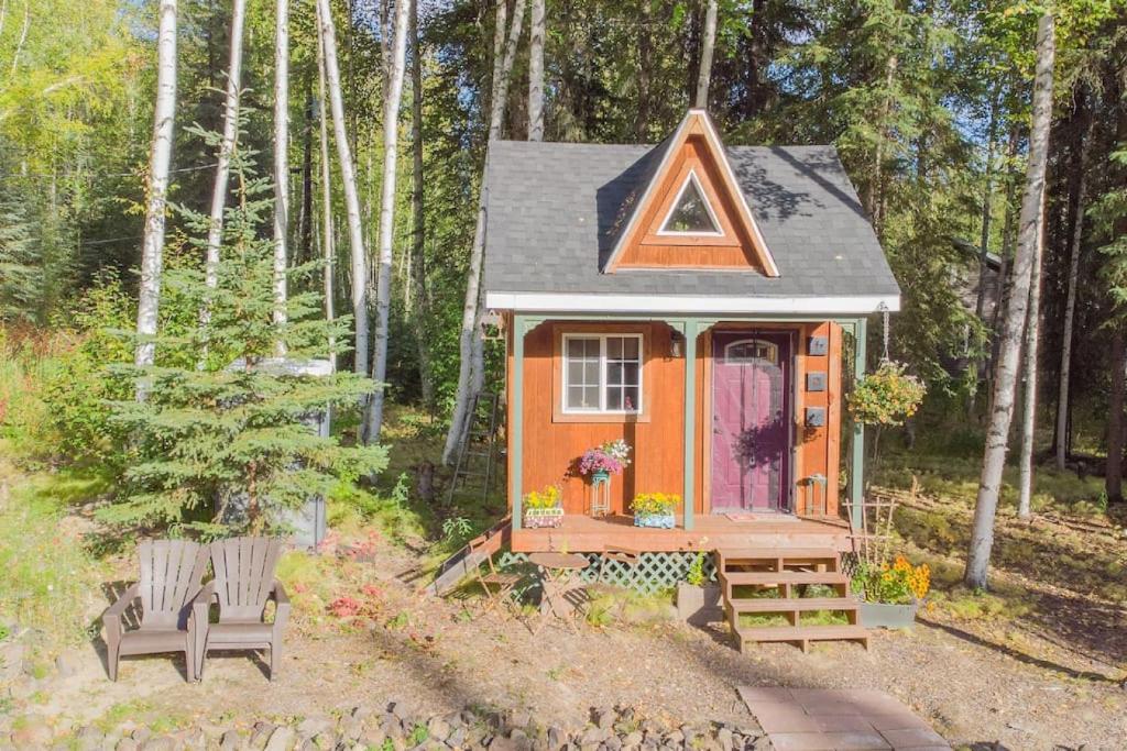 ein winziges Haus im Wald mit lila Tür in der Unterkunft The Skarland Trail Cabin in Fairbanks