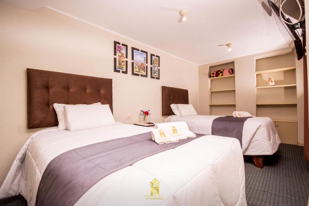 duas camas num quarto de hotel com lençóis brancos em Hostal Virreinal AQP em Arequipa