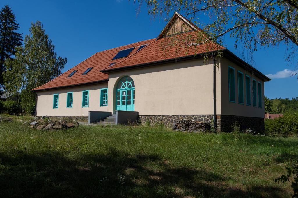 um edifício com telhado vermelho e janelas verdes em Villa Deco Parádsasvár em Parádsasvár