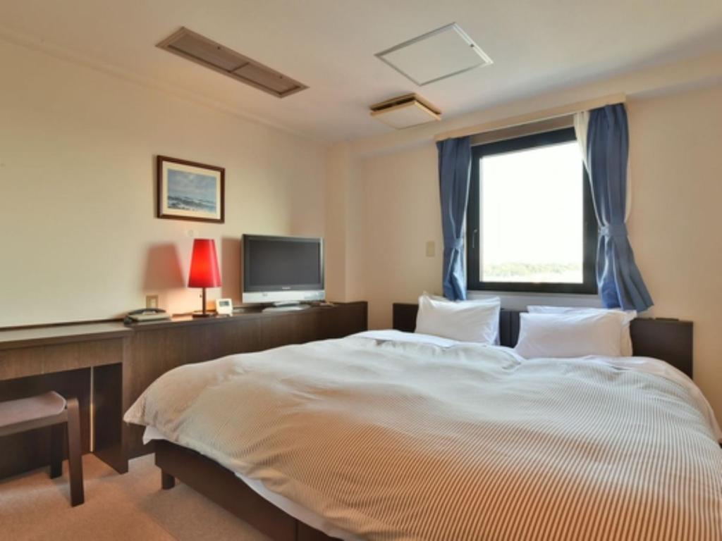 a bedroom with a large bed and a window at Suzuka Royal Hotel - Vacation STAY 38960v in Suzuka