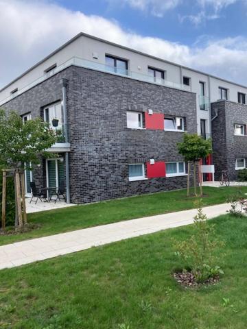 a large brick building with red windows and a yard at Ferienwohnung Troge in Greifswald