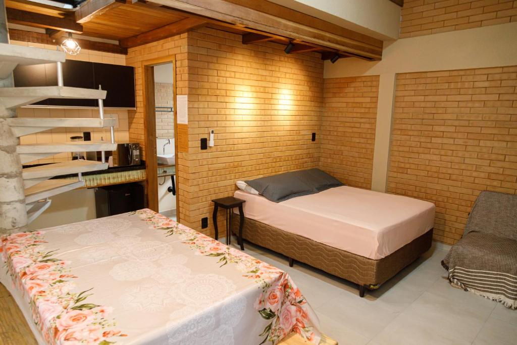 um quarto com 2 camas numa parede de tijolos em Casa Florescer da Madeira em Pomerode