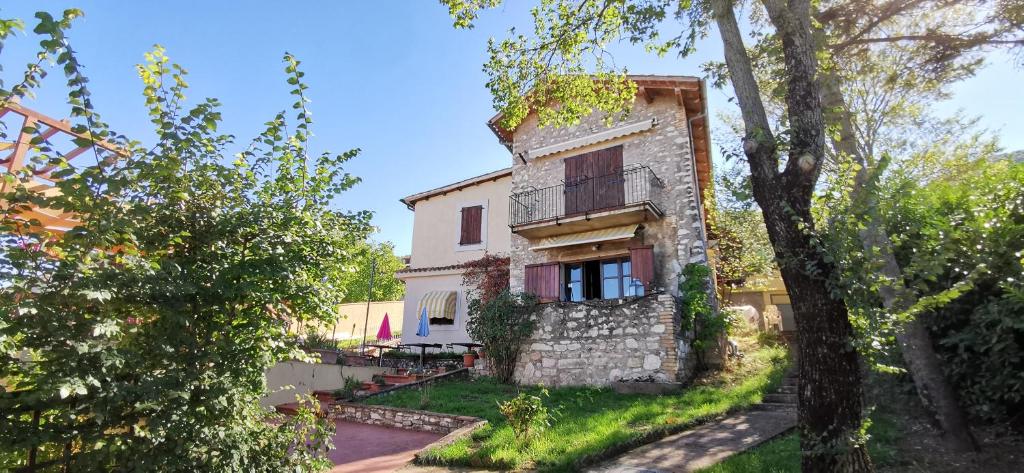 una vista exterior de una casa con árboles en Country House Trevi Umbria Borghetto Vetuliae, en Santa Maria in Valle