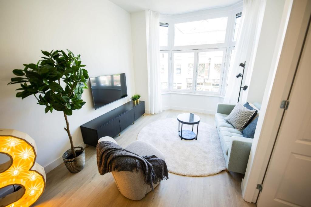 a living room with a couch and a tv at Blissfully 1 Bedroom Serviced Apartment 53m2 -NB306B- in Rotterdam