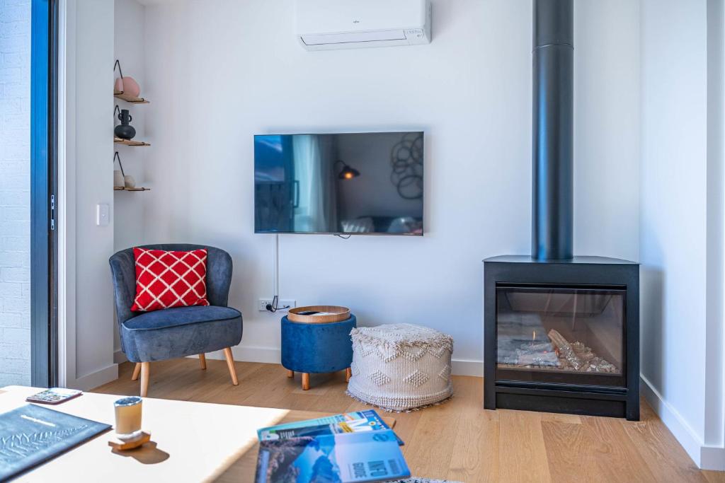 Riverside Lodge- 2 Bedroom Unit في Albert Town: غرفة معيشة بها موقد وكرسي