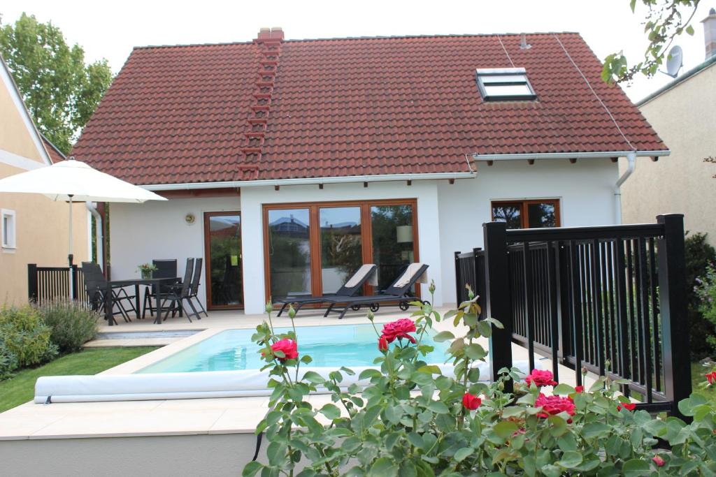 a small house with a swimming pool in the backyard at Ferienhaus Kaiserbaum in Illmitz