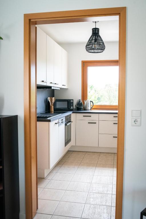 a kitchen with white cabinets and a window at Ferienhaus Kaiserbaum in Illmitz