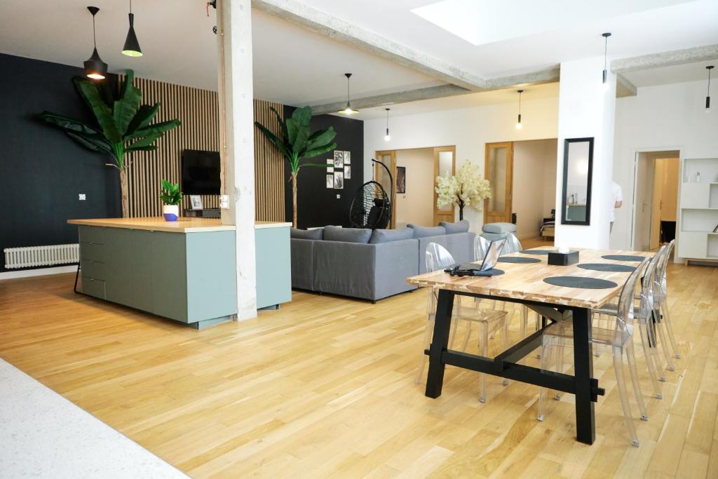 uma sala de estar com uma mesa e um sofá em Loft aux portes de Paris - Parking gratuit em Bagnolet