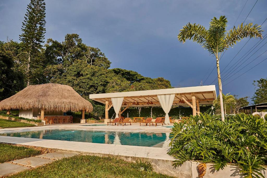 einen Pool mit Pavillon neben einem Resort in der Unterkunft PETRA SANTA HOTEL BOUTIQUE in Pereira