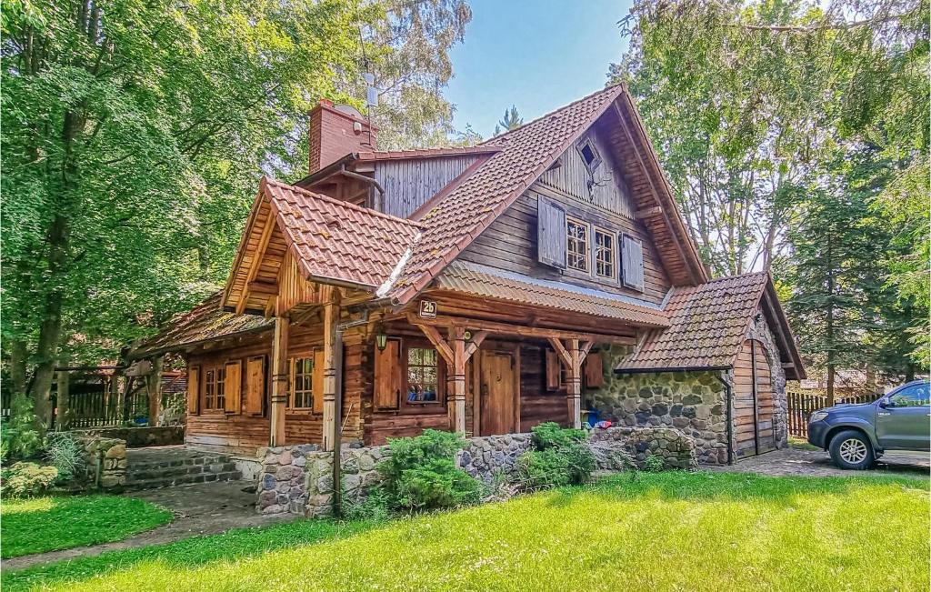 a wooden house with a gambrel roof at Nice Home In Ruciane Nida With Wifi in Ruciane-Nida