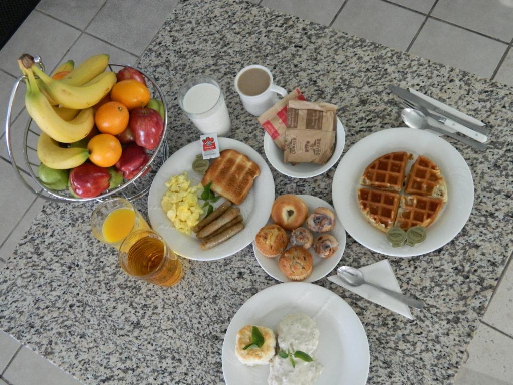 una mesa cubierta con platos de comida y fruta en California Inn Barstow, en Barstow