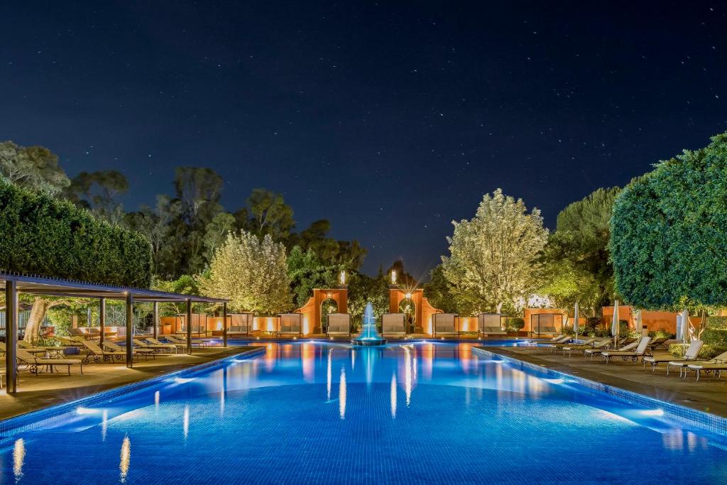 una gran piscina por la noche con sillas y una fuente en Fiesta Americana Hacienda Galindo Resort & Spa en Galindo