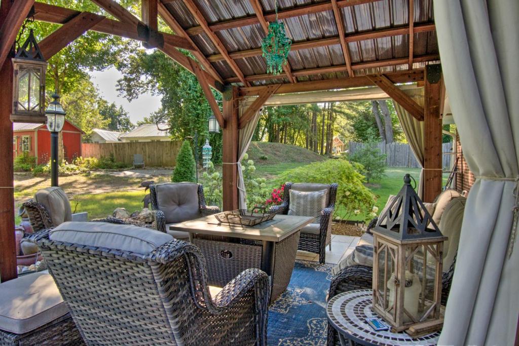 a patio with a table and chairs under a wooden pergola at Charming Florence Getaway with Fireplace and Grill! in Florence