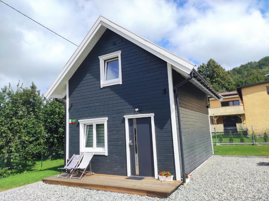 een blauw huis met een veranda en een stoel bij Domek na Blejchu in Wisła