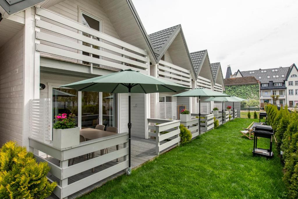 a house with an outdoor patio with an umbrella at DOMKI ZACHÓD SŁOŃCA w Ustroniu Morskim in Ustronie Morskie