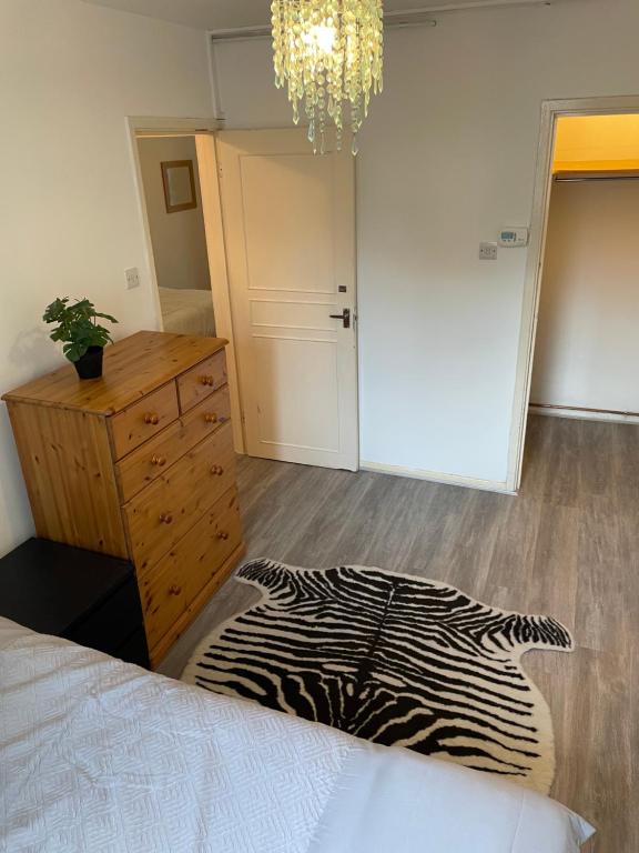 a bedroom with a bed and a dresser and a zebra rug at Central London Serviced Apartment near Borough station SE1 in London