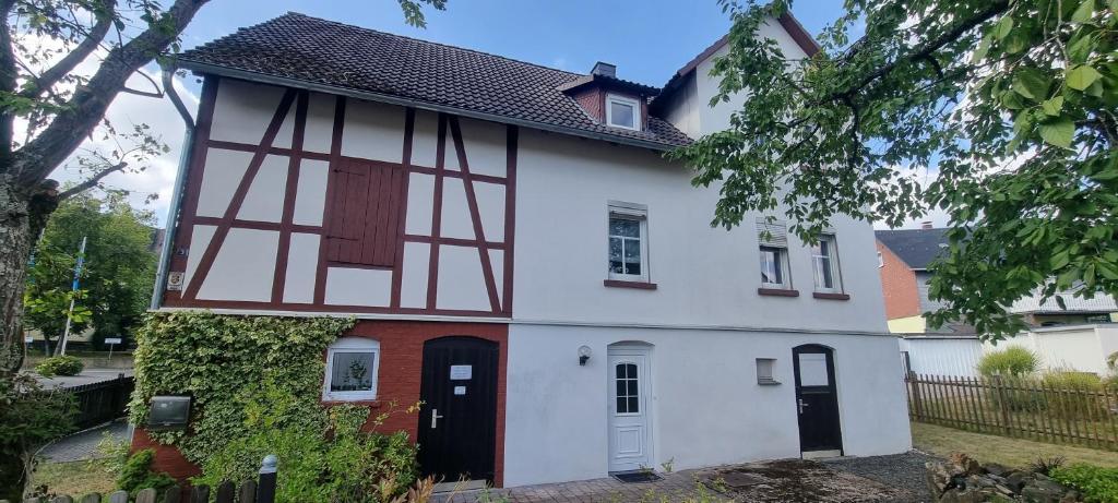 a white and red house with a black door at Ferienhaus Schuldienersch in Biedenkopf