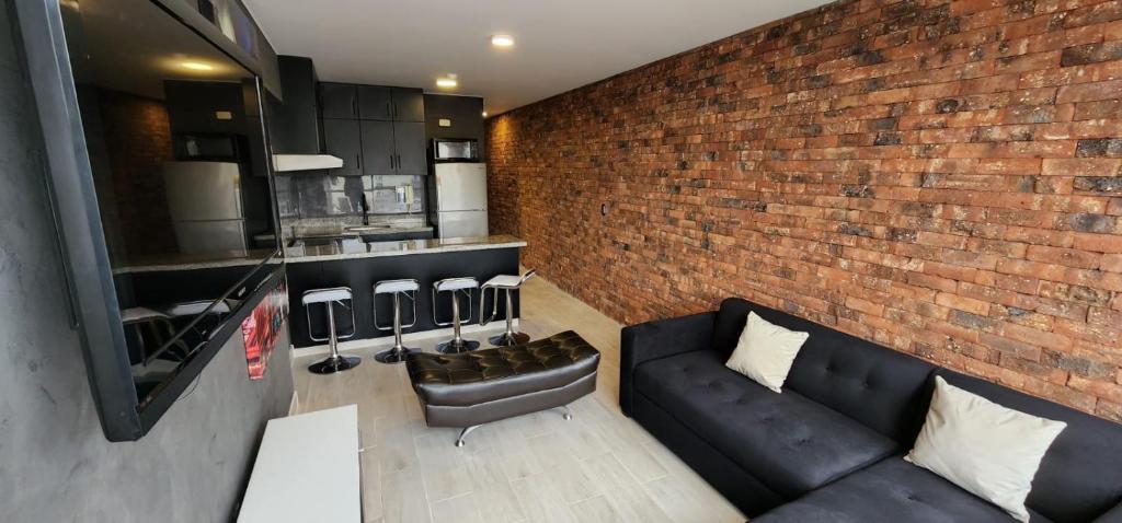 - un salon avec un canapé et un mur en briques dans l'établissement Grimaldo del Solar 219 Miraflores OMM1, à Lima