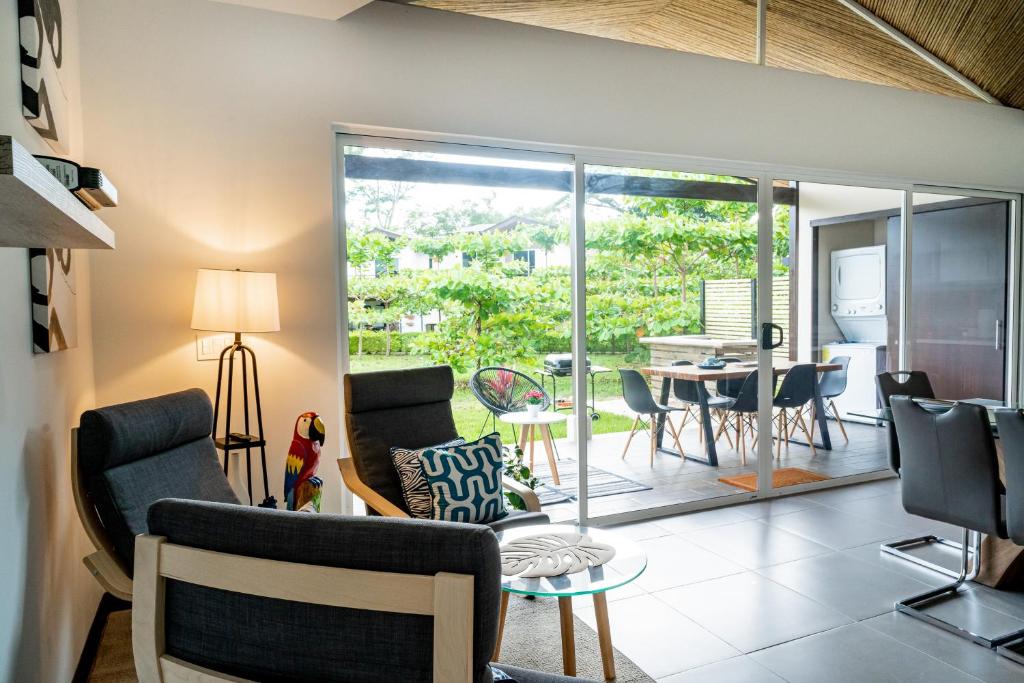 a living room with chairs and a table and a dining room at Ciudad del Mar 104 in Jacó