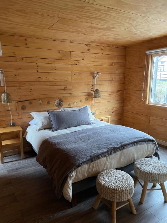 a bedroom with a bed in a wooden wall at Hotel Palafito Entre Mar y Tierra in Castro