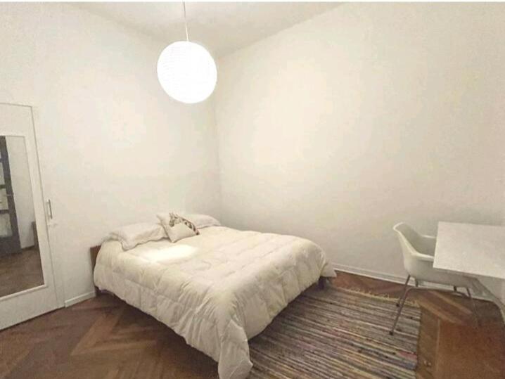 1 dormitorio con cama, escritorio y lámpara en Cálido apartamento a 8 cuadras del mar y a 3 de 18 Julio Hay una gatita que vive allí en Montevideo