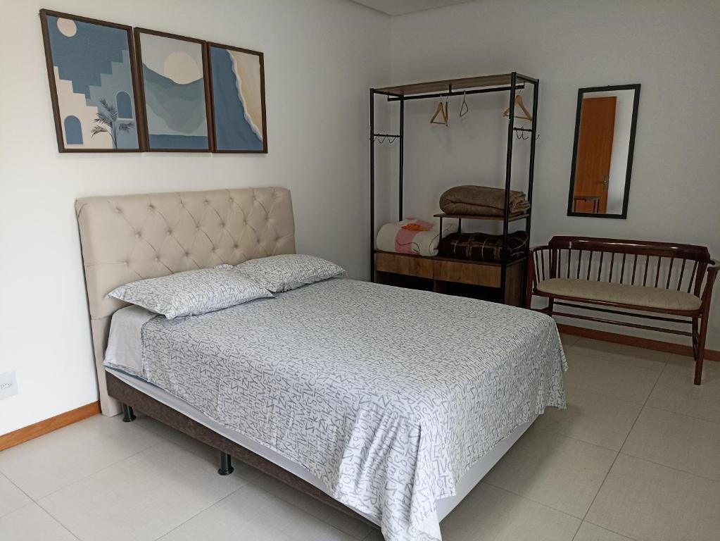 a bedroom with a bed and a mirror at Flat Santa Cruz II in Santa Cruz do Sul