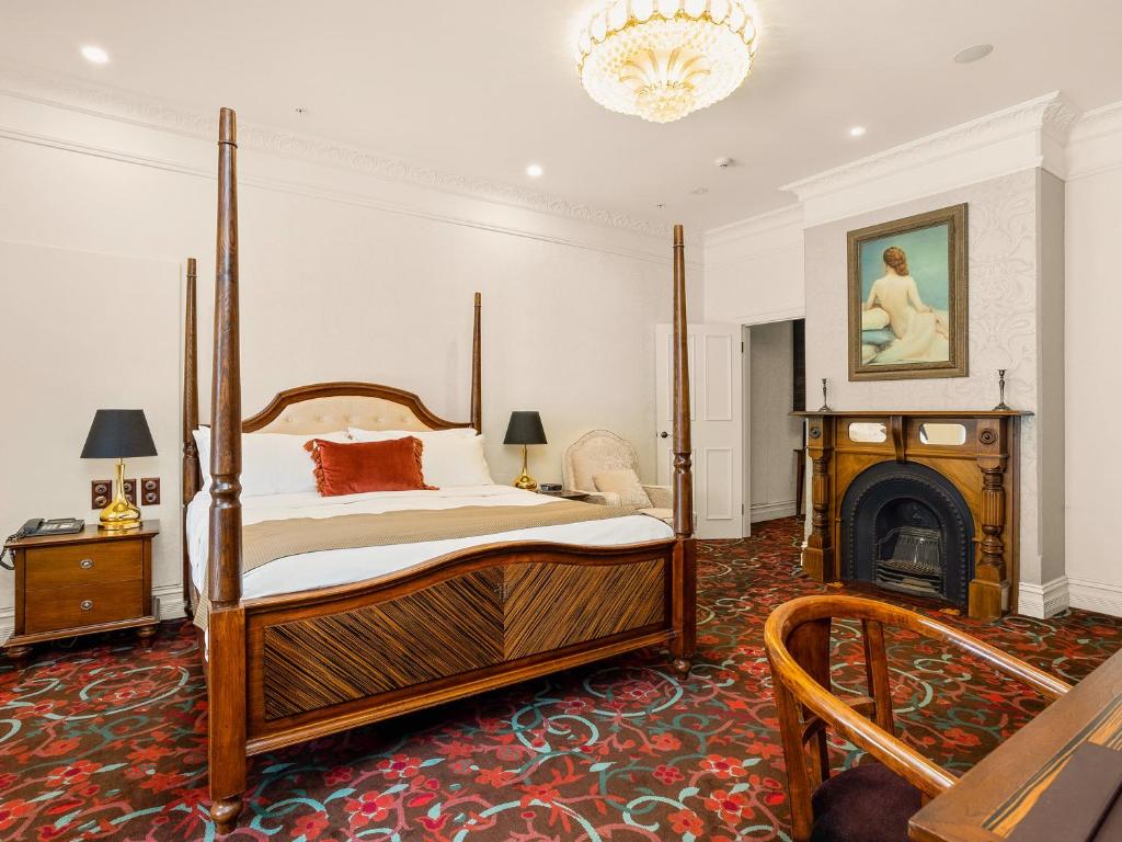 a bedroom with a canopy bed and a fireplace at The Terrace Hotel in Perth