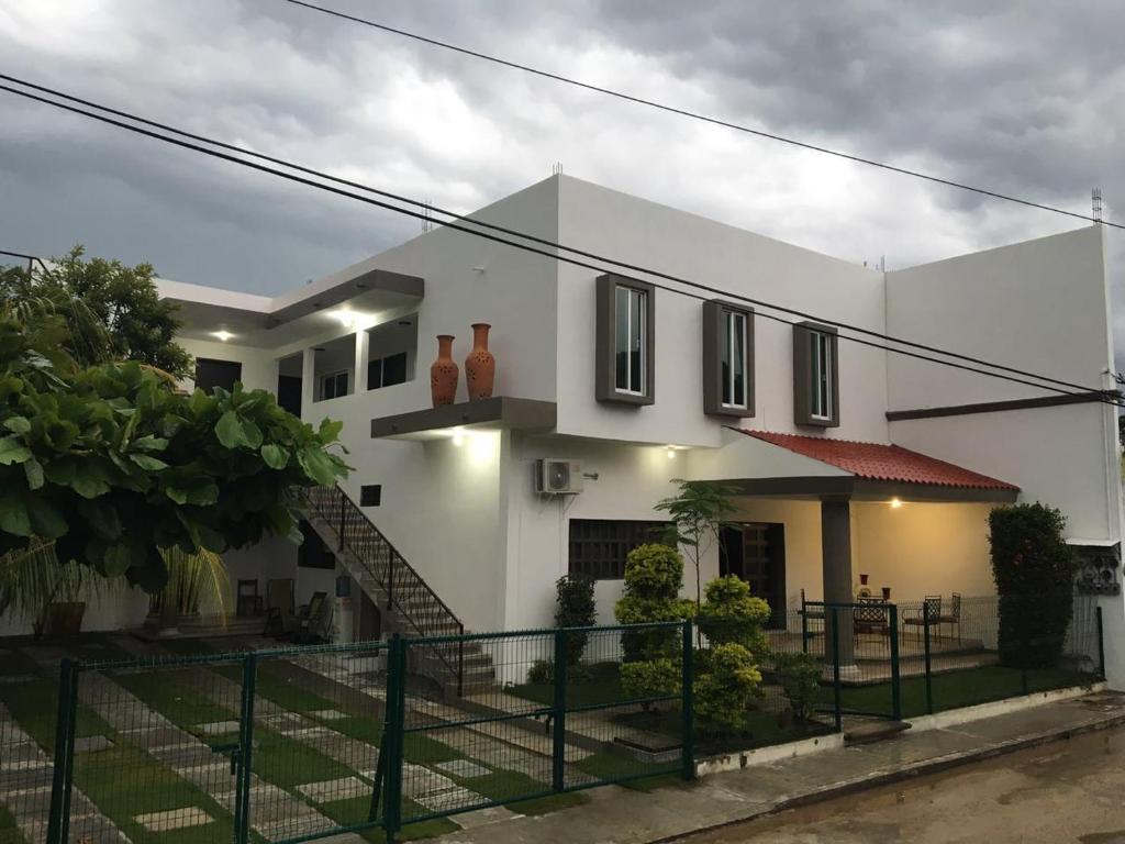 a white house with a staircase in front of it at Hotel Garden Suites Tonalá in Tonalá