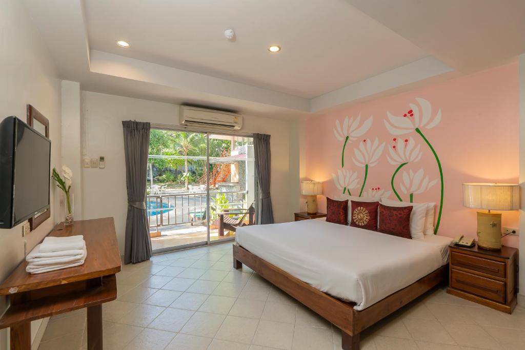 芭達雅中心的住宿－Bella Villa Pattaya 3rd Road，一间卧室设有一张床、一台电视和一个窗口。