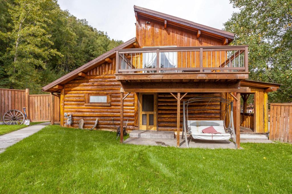 a log cabin with a deck and a lawn at Indian AK 25 min to Anchorage & 25 min to Girdwood in Anchorage