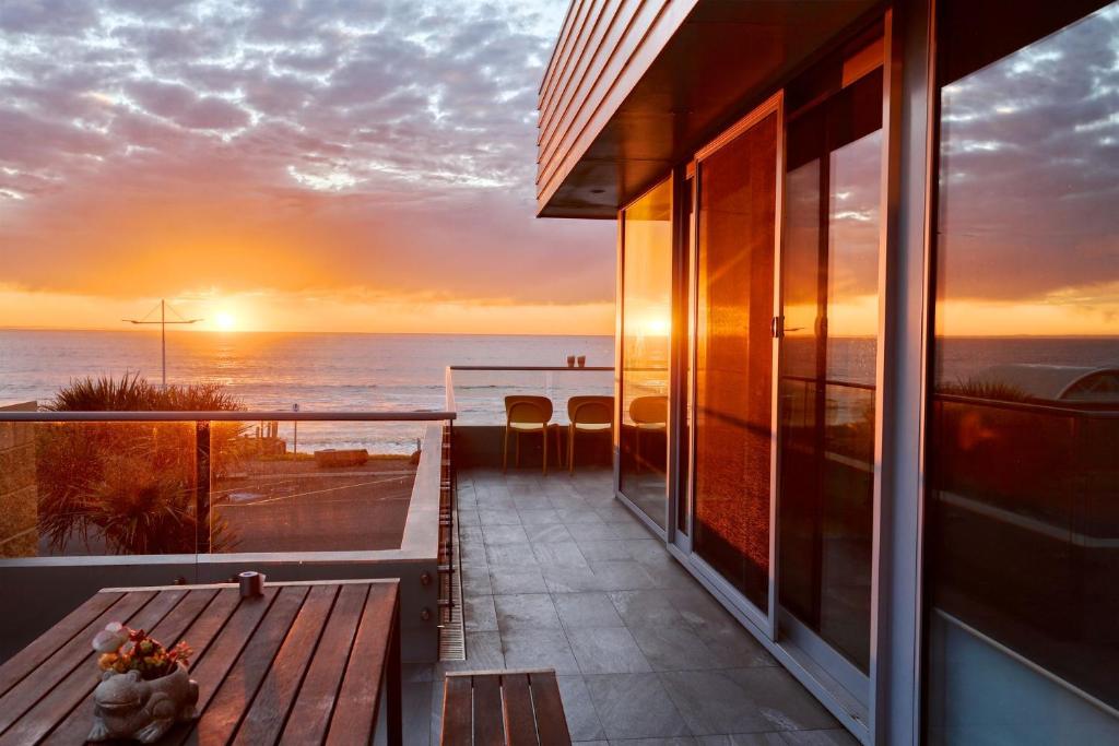 einen Balkon mit Blick auf das Meer bei Sonnenuntergang in der Unterkunft 103 Beach Street in Port Fairy