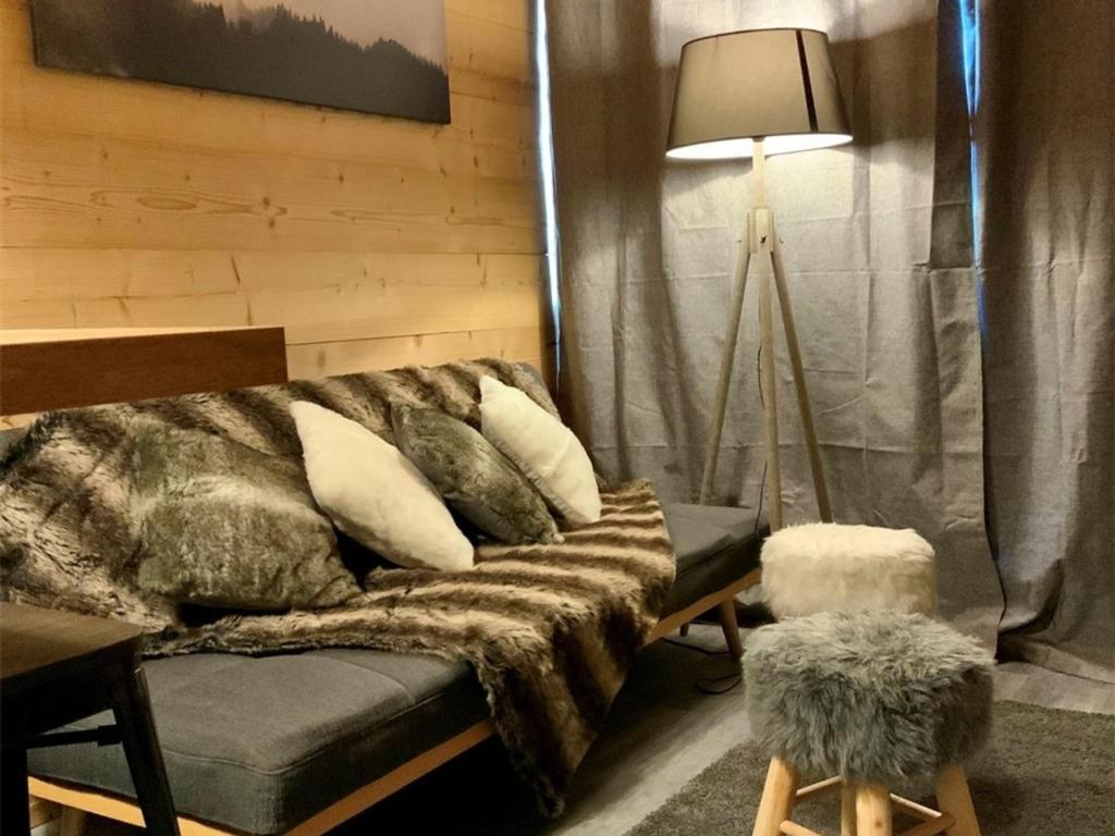 een woonkamer met een bank en een lamp bij Appartement Val Thorens, 3 pièces, 4 personnes - FR-1-637-44 in Val Thorens