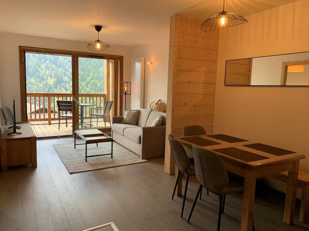 ein Wohnzimmer mit einem Tisch und ein Wohnzimmer mit einem Sofa in der Unterkunft Magnifique 2 pièces équipé avec garage privé à Châtel - FR-1-198-239 in Châtel