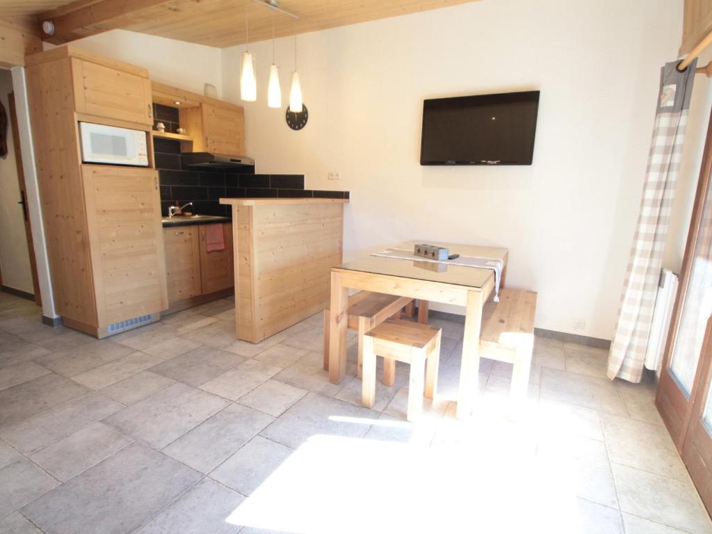 a kitchen with a table and a tv on the wall at Appartement Les Carroz d'Arâches, 2 pièces, 4 personnes - FR-1-572-259 in Arâches-la-Frasse