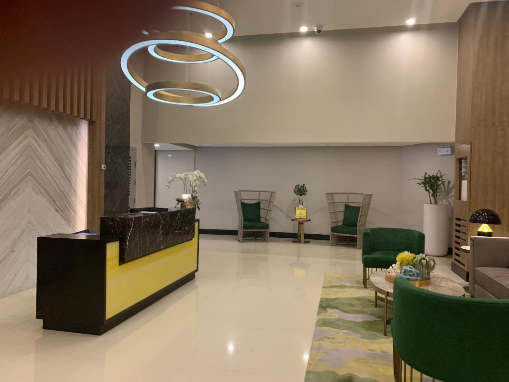 a lobby with a reception desk and green chairs at Le Maisse Executive Studio 1BR opp Okada in Manila