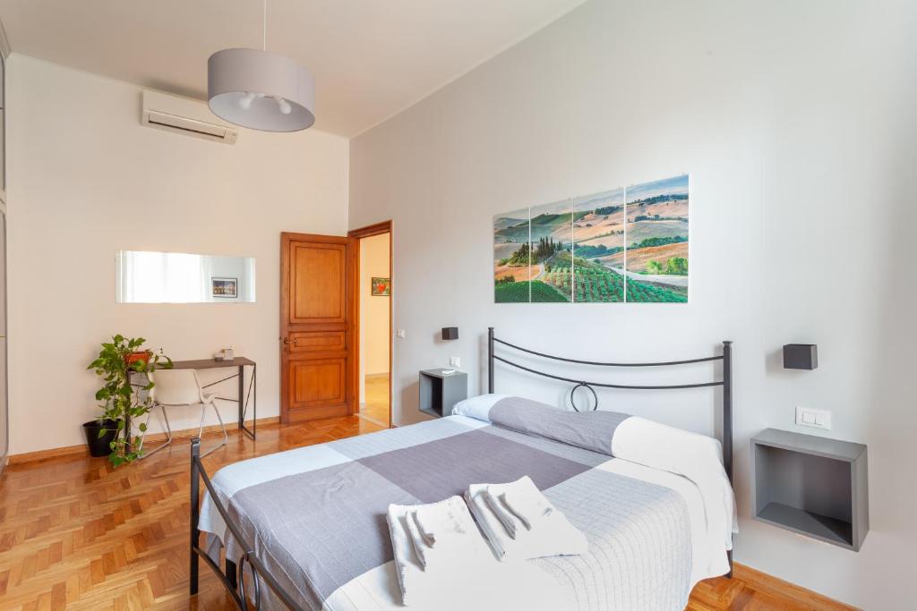 a bedroom with a bed and a desk and a tv at Il Melograno Holiday House in Rome