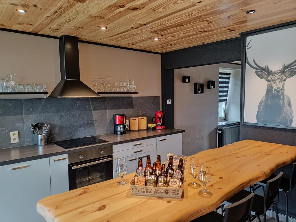 una cocina con una mesa de madera con botellas. en Gîte 28 court en Bastogne