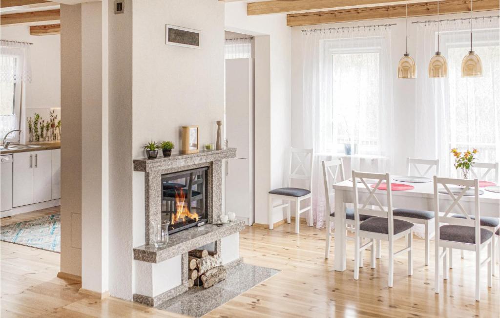 salon z kominkiem i stołem w obiekcie 4 Bedroom Amazing Home In Ruciane-Nida w mieście Karwica