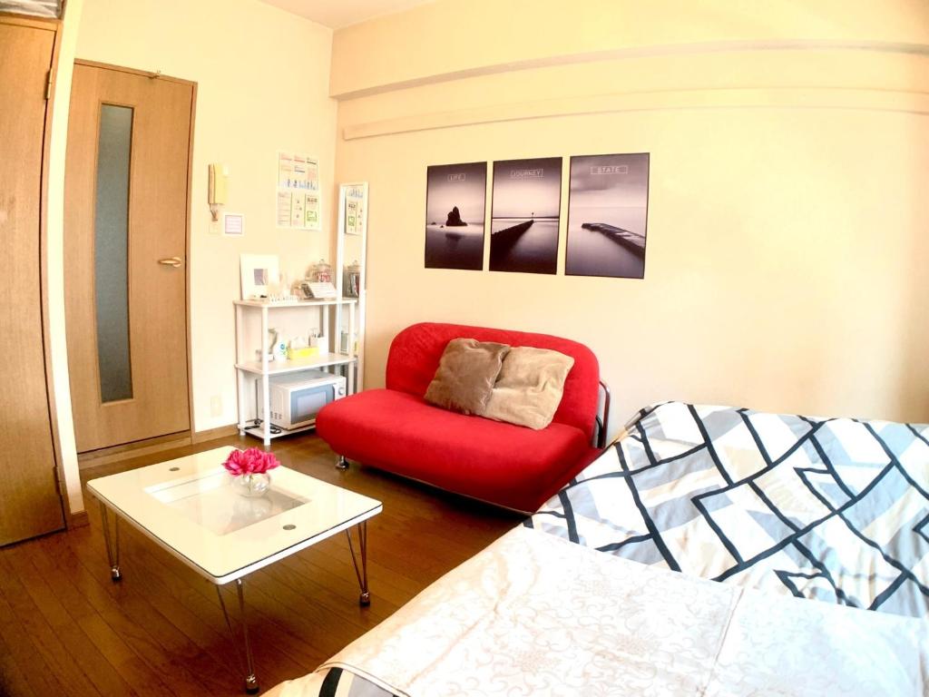 un soggiorno con divano rosso e tavolino da caffè di Diamante Yakuin - Vacation STAY 71953v a Fukuoka