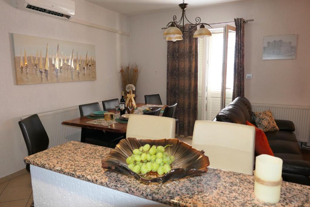 Sala de estar con mesa y tazón de uvas en APARTMENT MARKO, en Senj