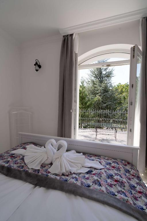 a bedroom with a bed with two swans on it at Villa Rose Garden in Nyíregyháza